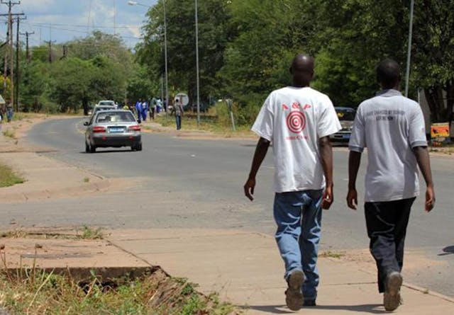 Two men walking down a road in Botswana