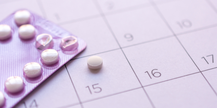 Birth-control pill with date of calendar background
