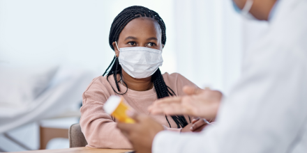 A teenager wearing a mask sees a healthcare worker