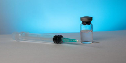 Close up of a vial of medicine and needle
