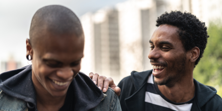 Two latino african male friends laughing