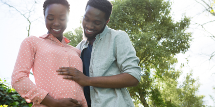A pregnant woman and her partner smile