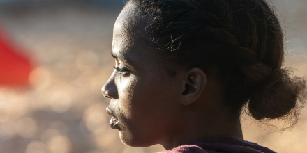 Backlit image of a serious young black woman looking away