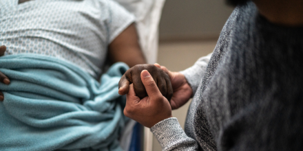 Man holding hospital patient's hand