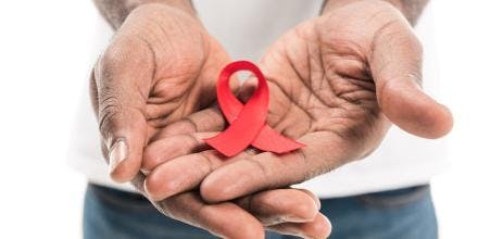 African-American man holding aids awareness red ribbon