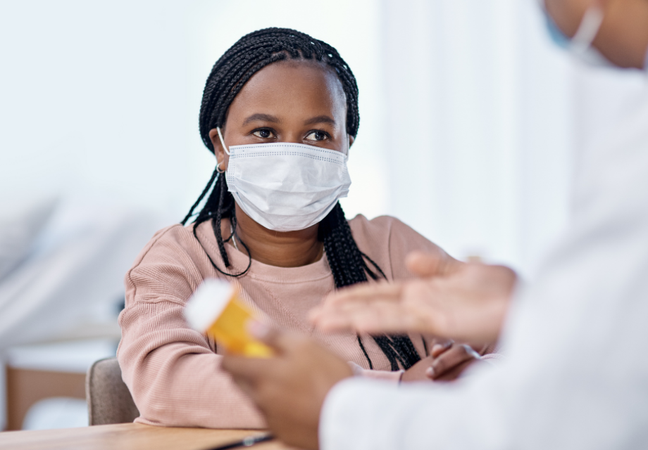 A teenager wearing a mask sees a healthcare worker