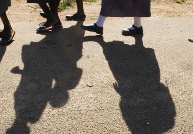 Close up of girls feet and their shadows as they walk home from school