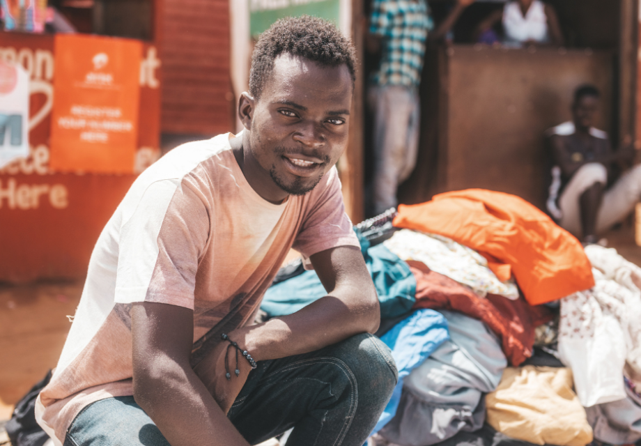 A young Malawian man sits at a market
