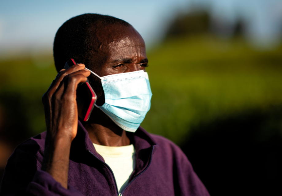A man wearing a mask talking on a mobile phone
