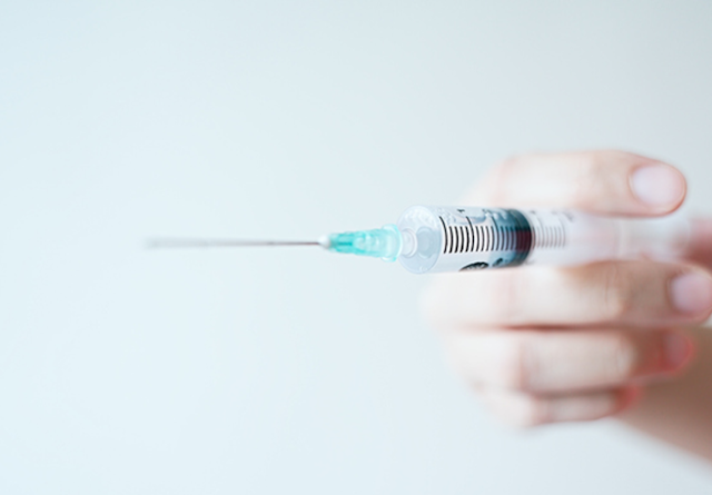 Close up of a syringe being held