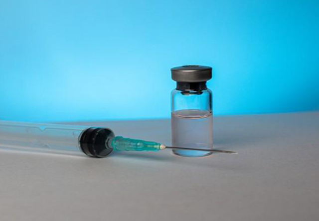 Close up of a vial of medicine and needle