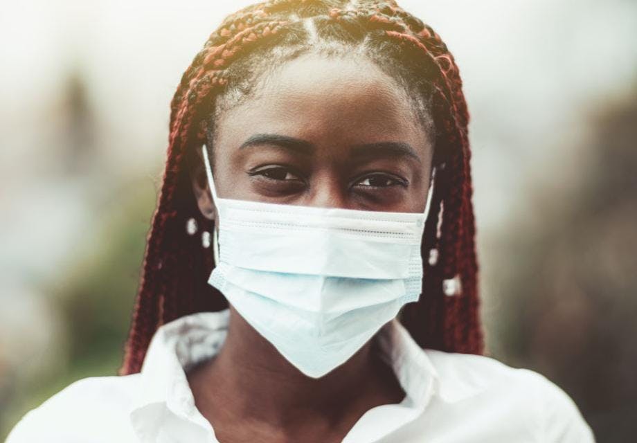 A young African woman wearing a medical face mask