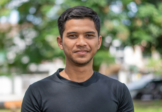 Portrait of a Malaysian young man making a smiling face and looking at the camera.