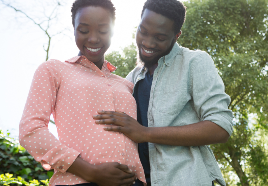 A pregnant woman and her partner smile