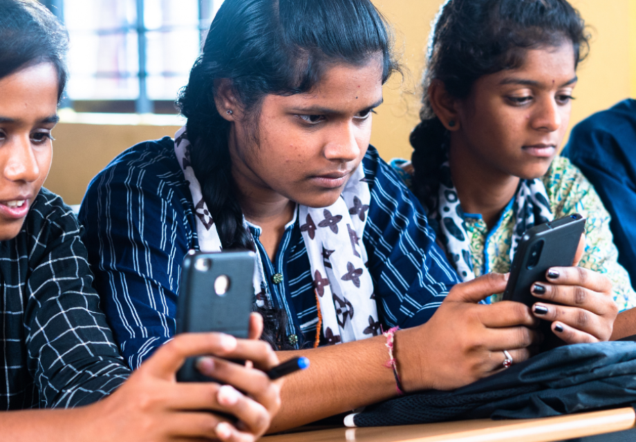 Three adolescent girls looking at their mobile phones