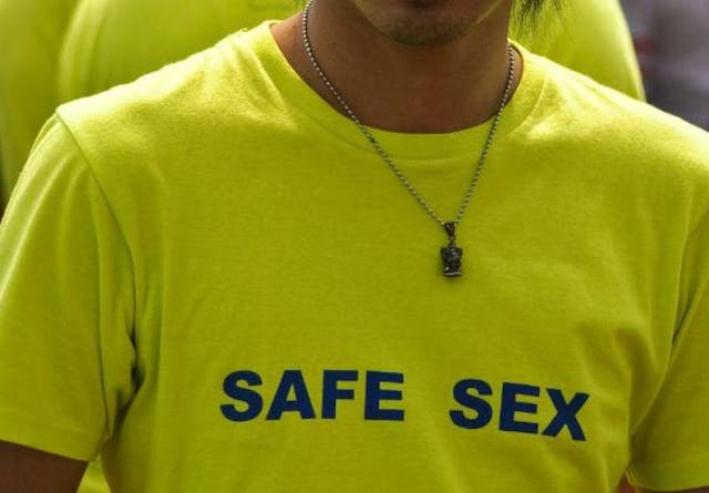 A man in Thailand wearing a yellow t-shirt that reads 'safe sex'