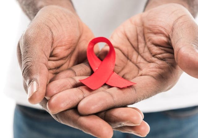 African-American man holding aids awareness red ribbon