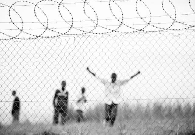 Men celebrating inside a barbed fence 