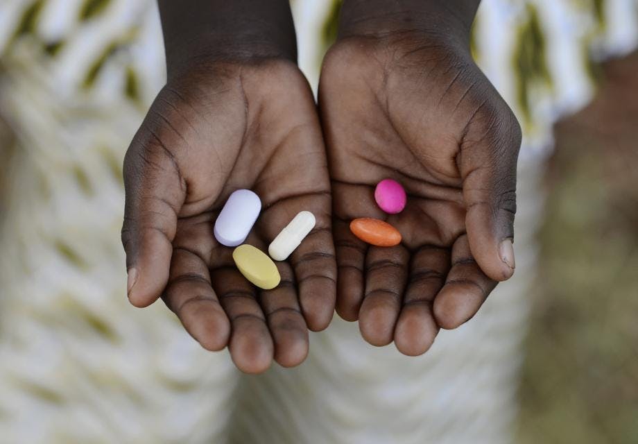 Black African boy holding pills to cure diseases. Unfortunately, in Africa there are lots of diseases like malaria, pneumonia, AIDS or simple Diarrhoea. Thereforem, medicine and healthcare pills are very important in the black continent.