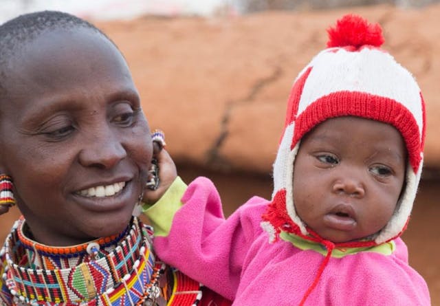 Smiling Maasai mother with young daughter