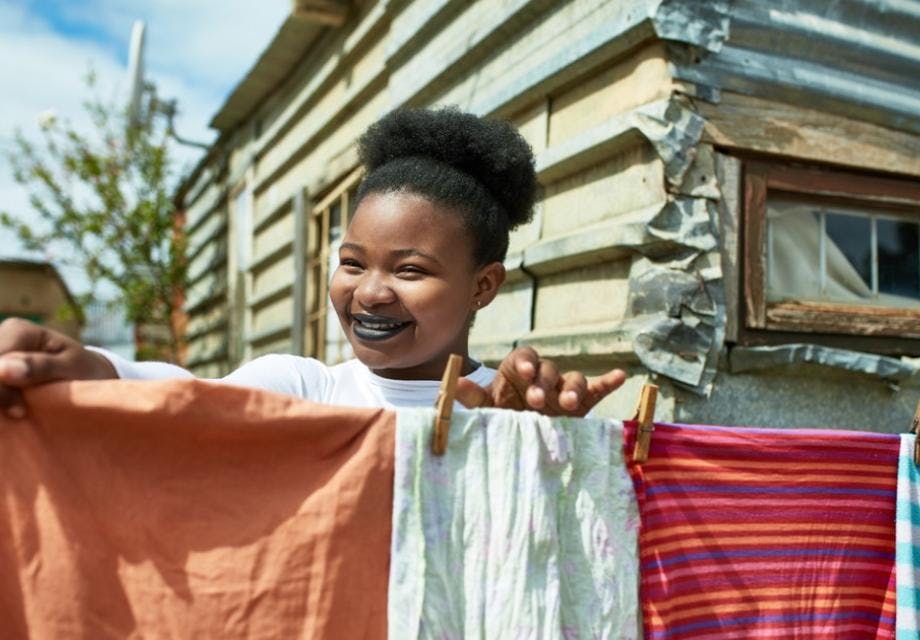 Smiling woman drying laundry outside