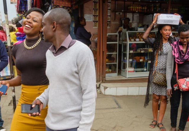 People laughing and socializing on a busy street in downtown Nairobi