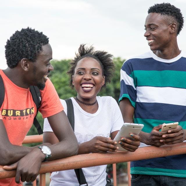 Groung of young people smiling of their phones